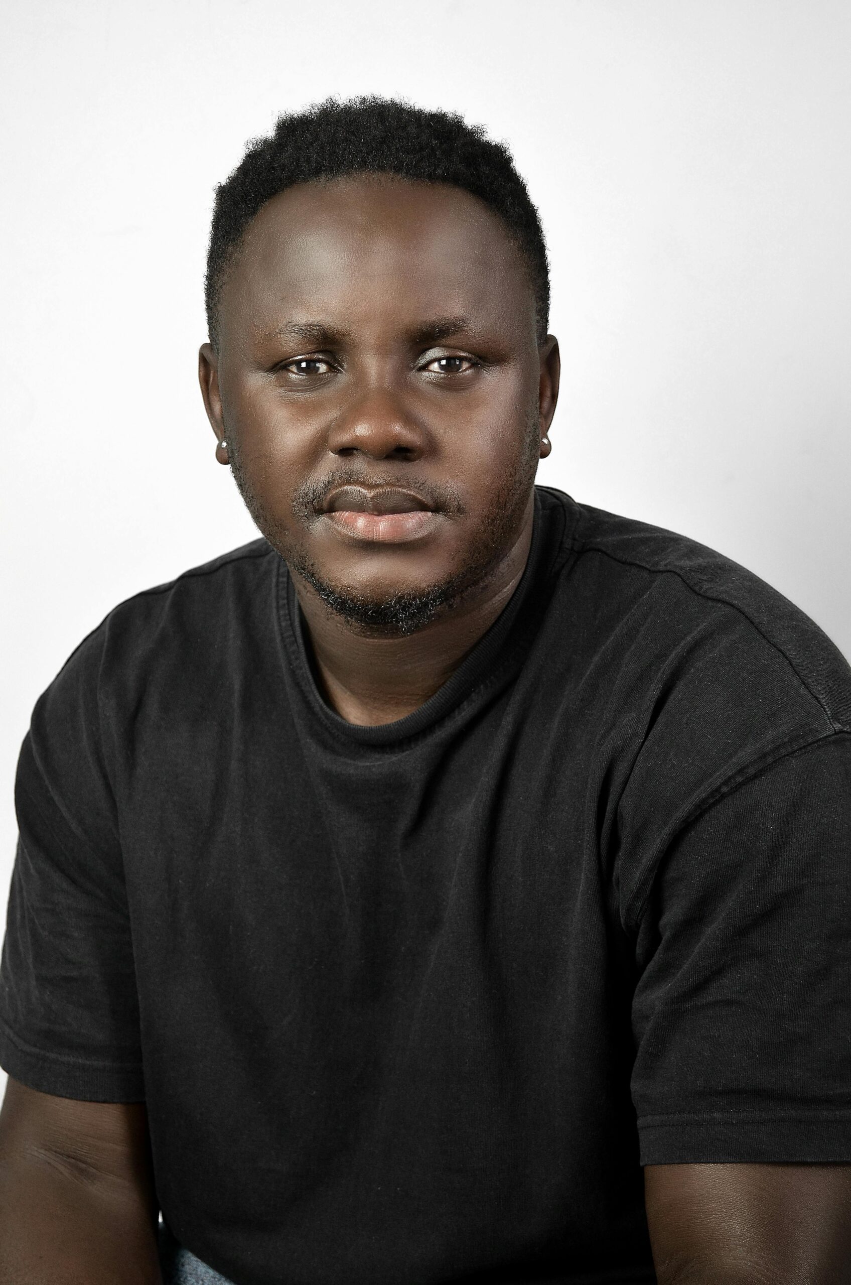 Confident man posing indoors wearing a black shirt.